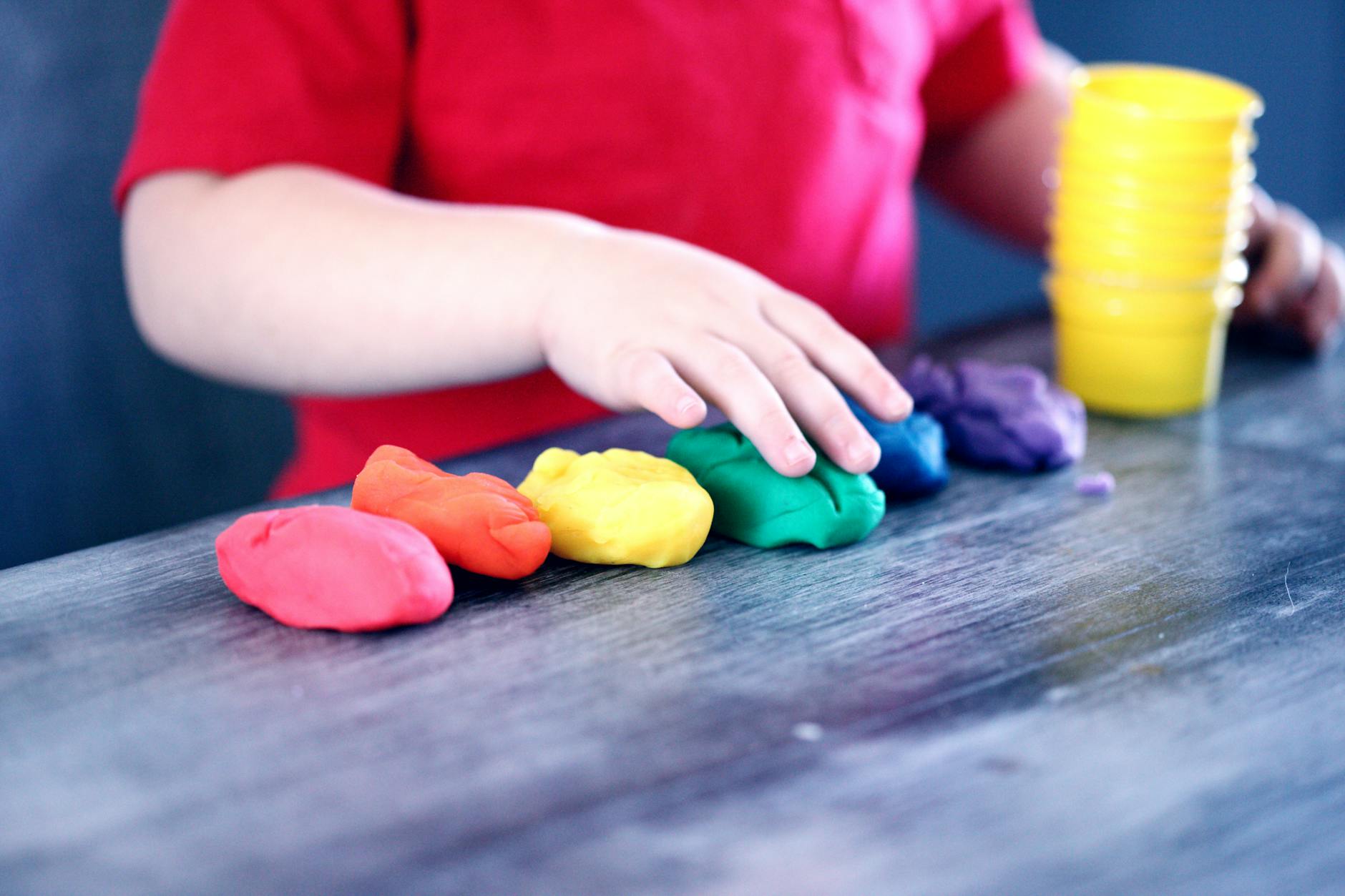 Child strengthening hand muscles while playing with therapy putty in occupational therapy session in London, Ontario