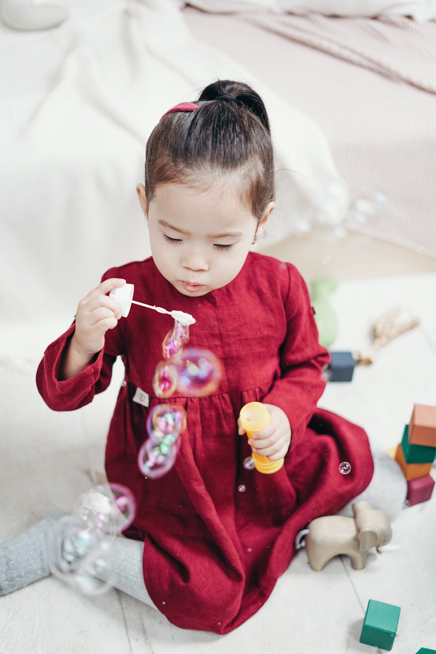 Child practicing oral motor and sensory play by blowing bubbles during occupational therapy session in London, Ontario