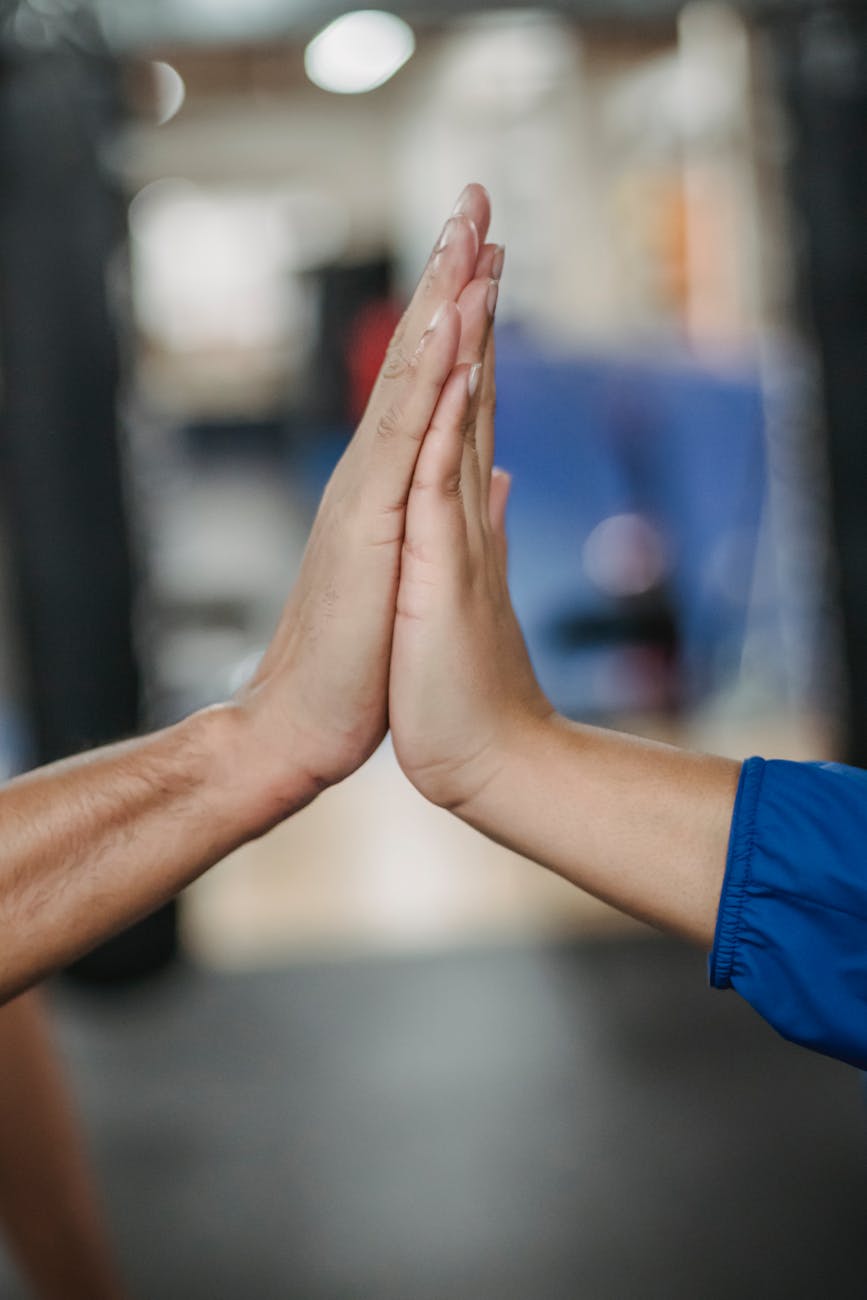 two people high-fiving, emphasizing the importance of being strengths based in occupational therapy sessions, with services offered in London, Ontario