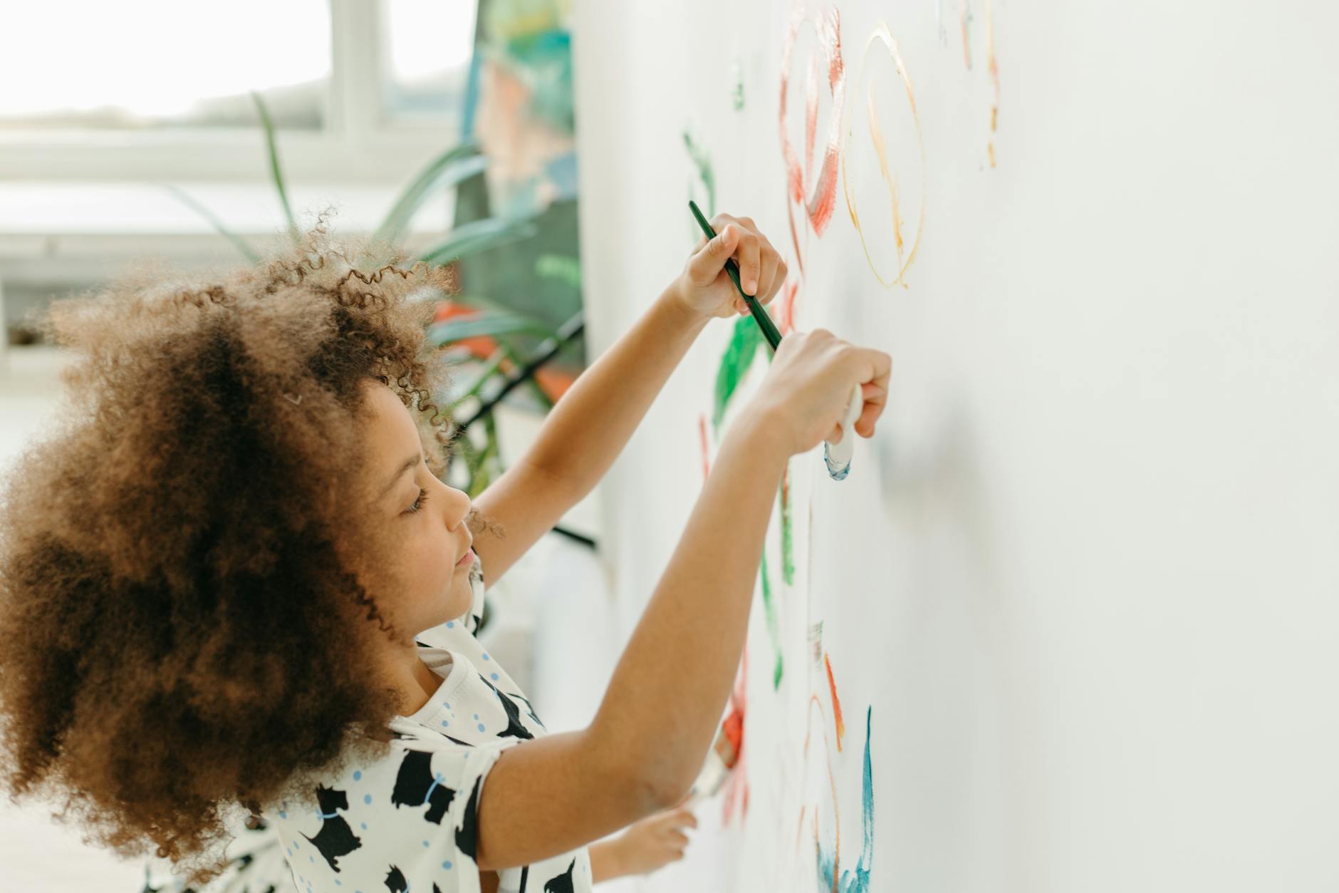 Child painting while working on fine motor skills and sensory exploration in occupational therapy session in London, Ontario